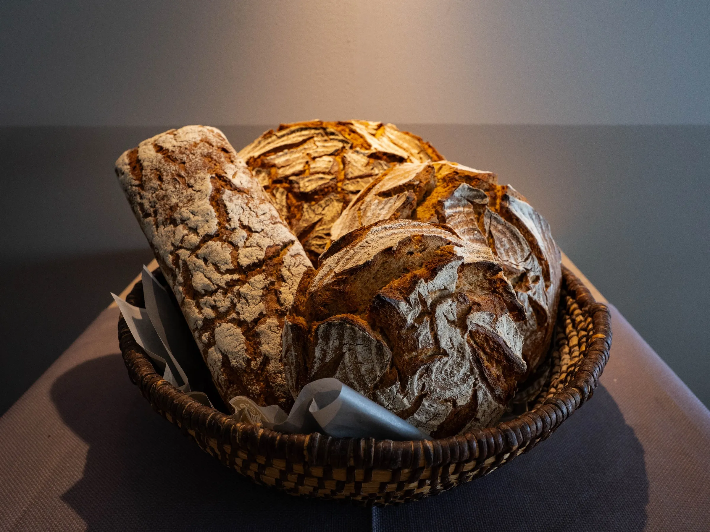 Bauernbrot als Laib und Wecken im Korb