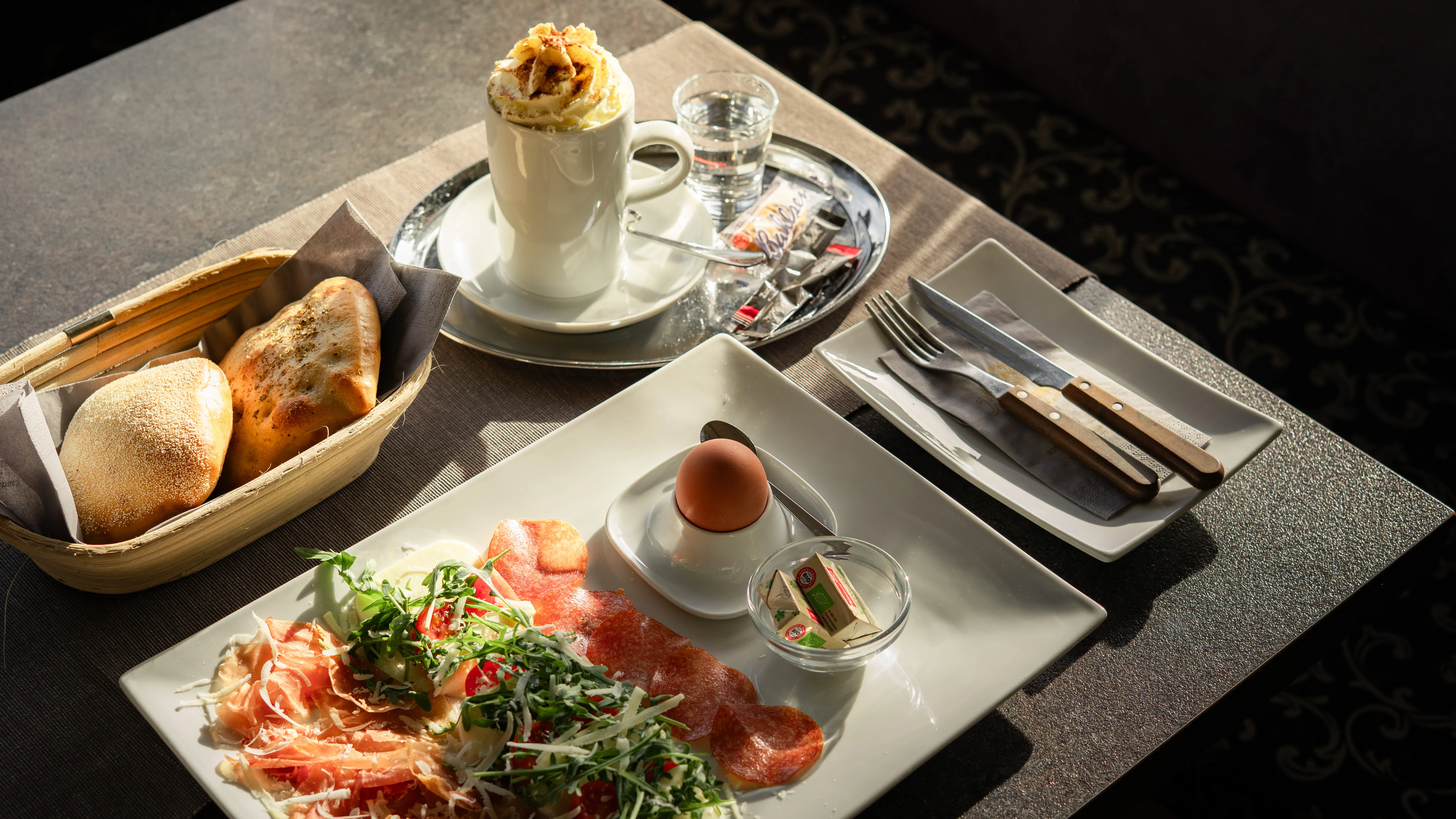 Italienisches Frühstück mit Prosciutto, Rucola und weichem Ei