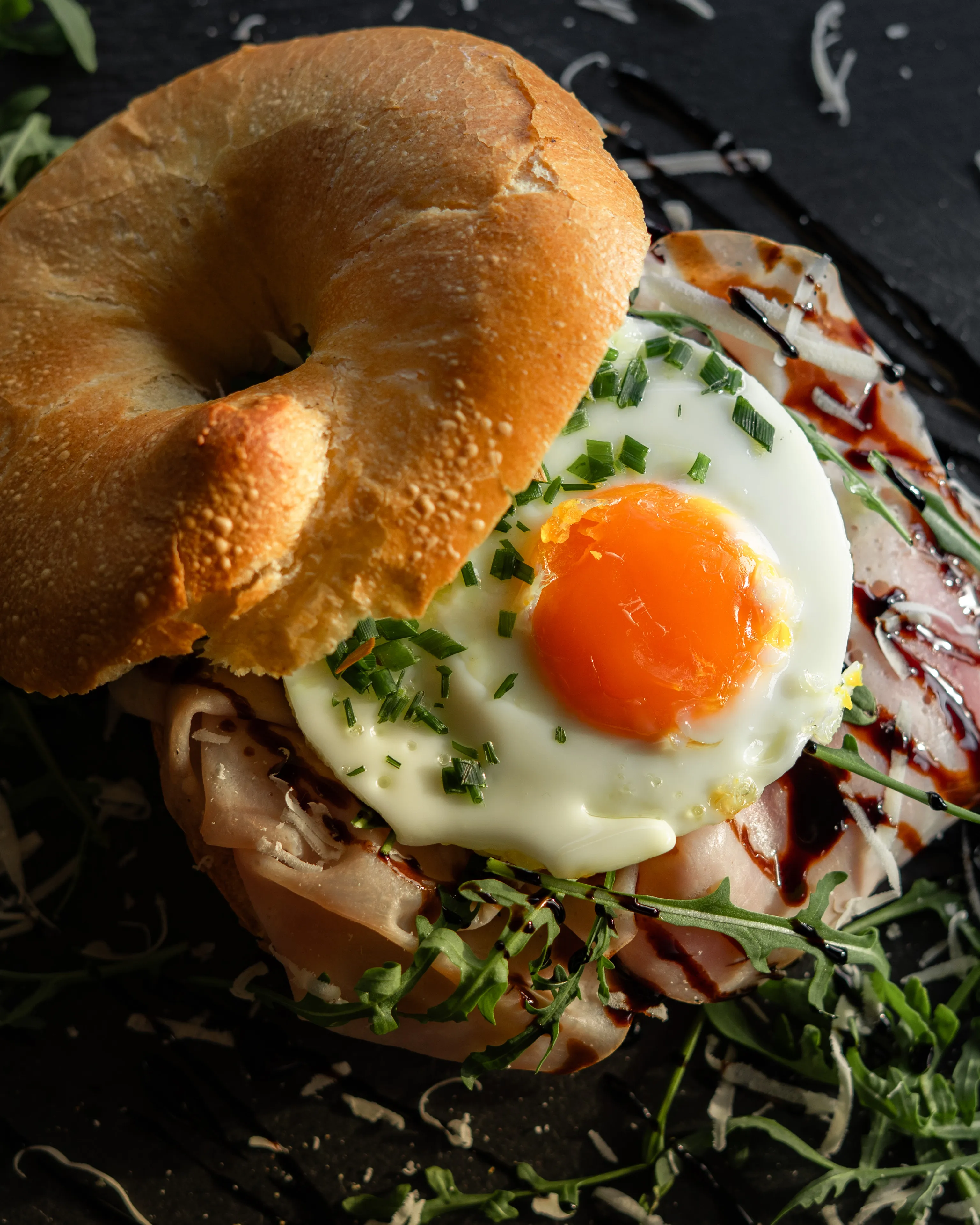 Bagel mit Schinken, Rucola, Spiegelei und Balsamico