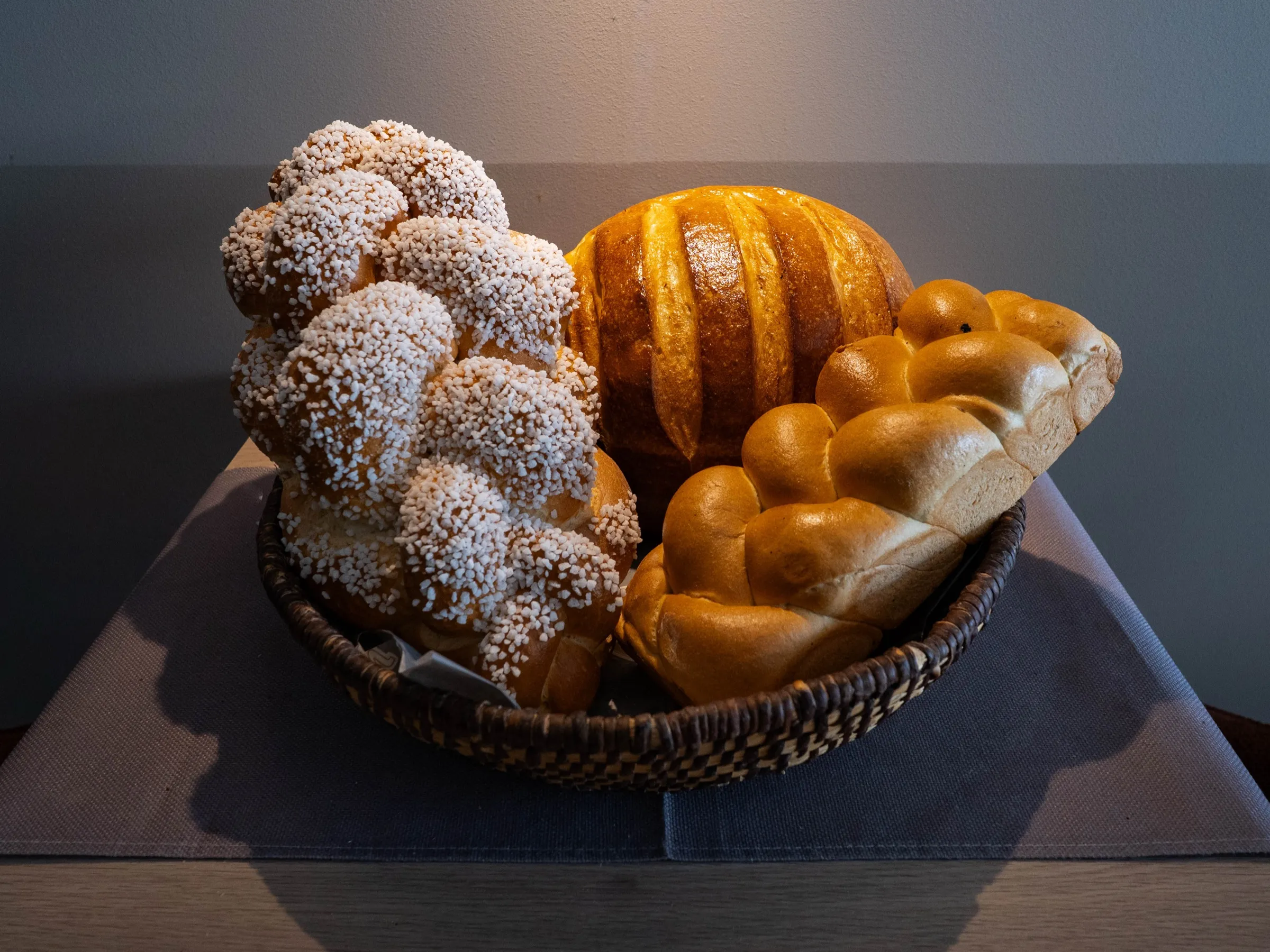 Striezel mit Hagelzucker, Rosinenbrot und Butterzopf im Korb