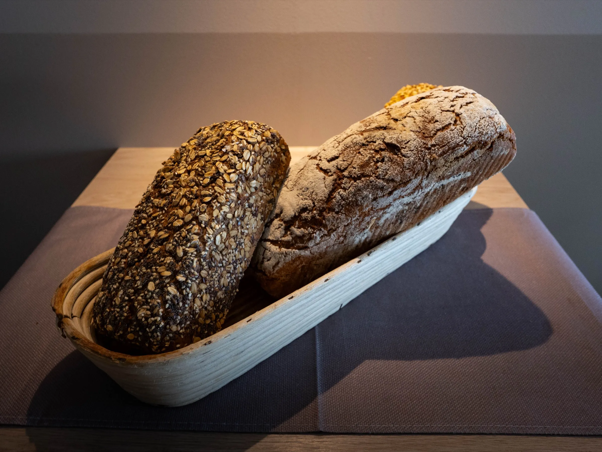 Vollkornbrote mit Saatenkruste im Gärkörbchen